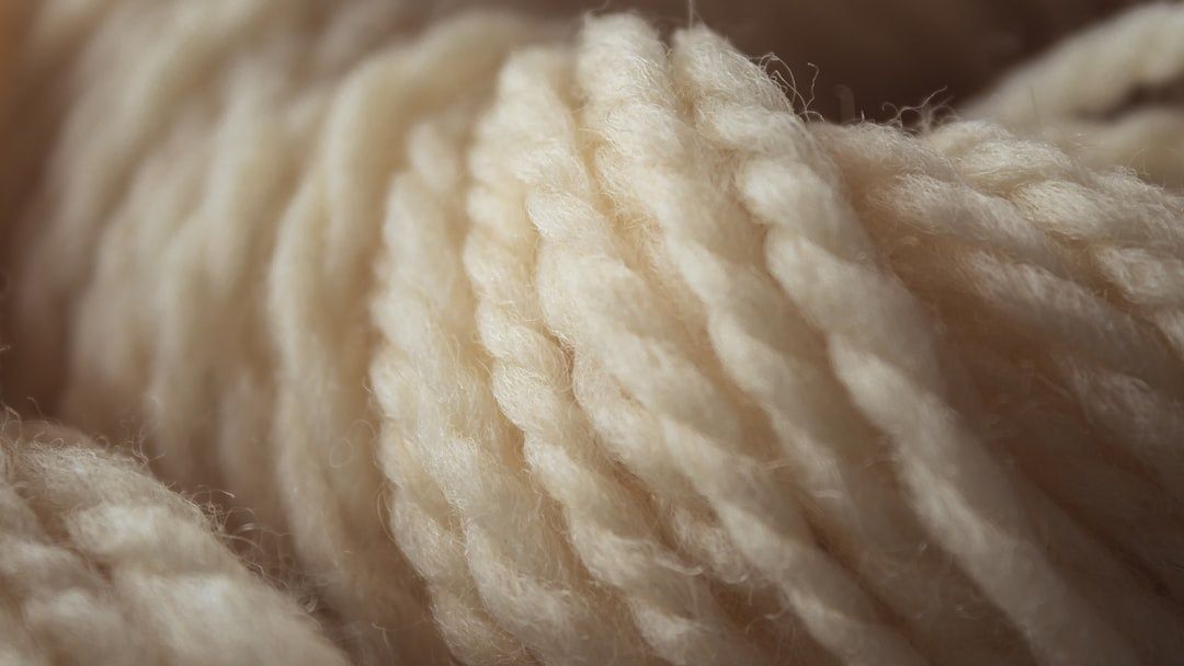 Nærbilde av myke, kremhvite ullfibre med tydelig struktur