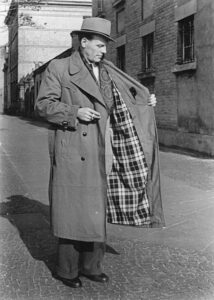 Svart-hvitt foto av mann som viser fôret i en lang trenchcoat
